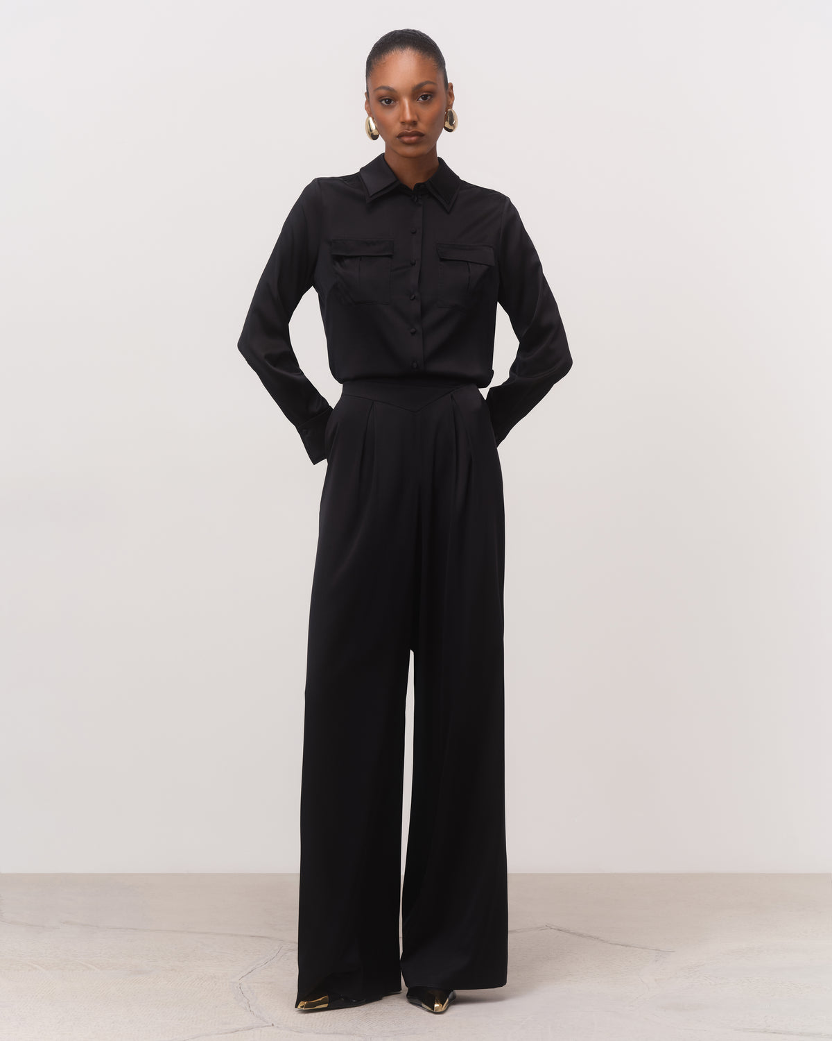 Front view of black silk belted shirt and wide-leg trousers with flared peplum hem