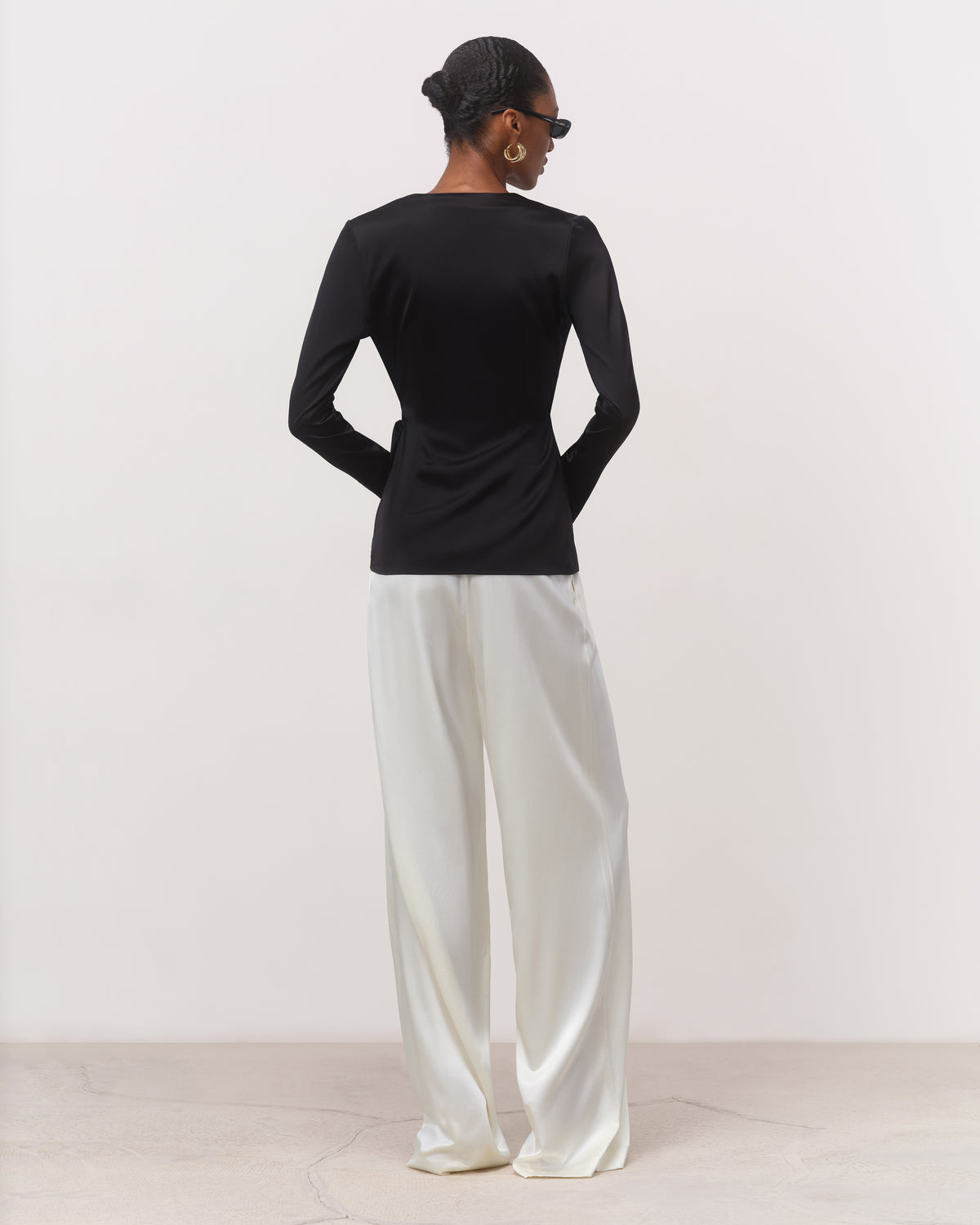 Back view of black silk wrap blouse with tailored buttoned cuffs