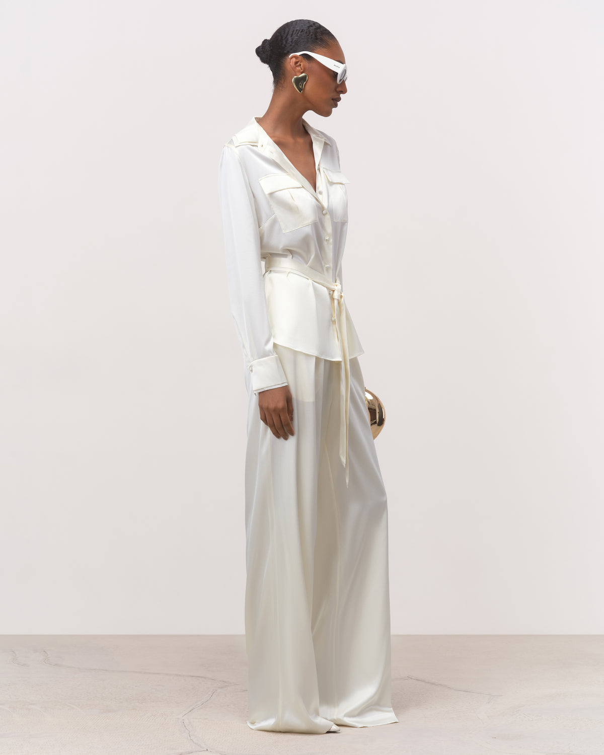 Side view of women's off-white silk shirt with tailored fit and peplum hem