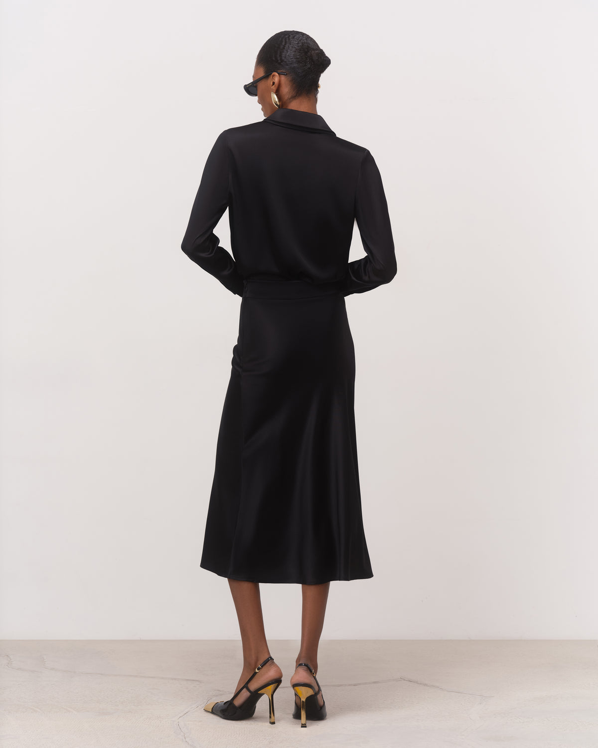 Back view of black bias cut silk skirt with fluid A-line hem