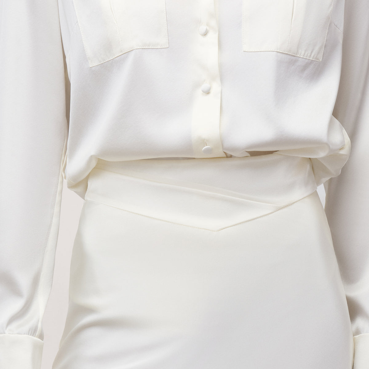 Close-up of white bias cut silk charmeuse midi skirt with cross-front V-waistband
