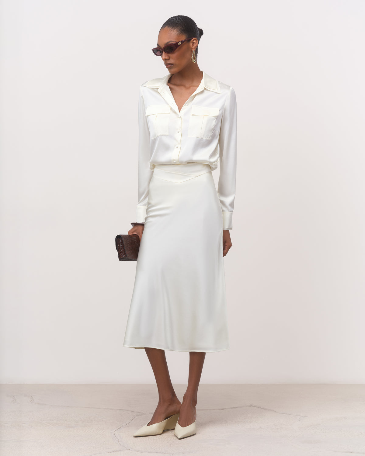 Anitas Muse Dubai pearl white bias cut silk midi skirt for women, worn with a white silk shirt, front view