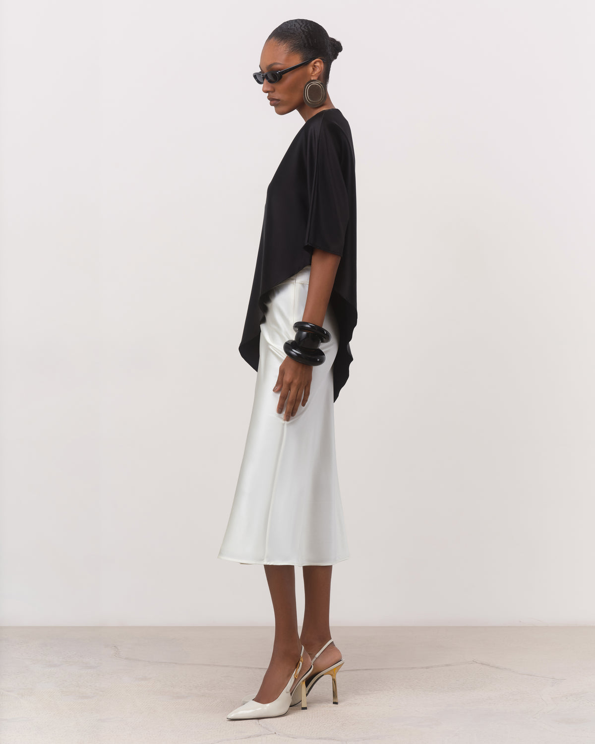 Black mulberry silk asymmetric top styled with a white silk skirt, side view