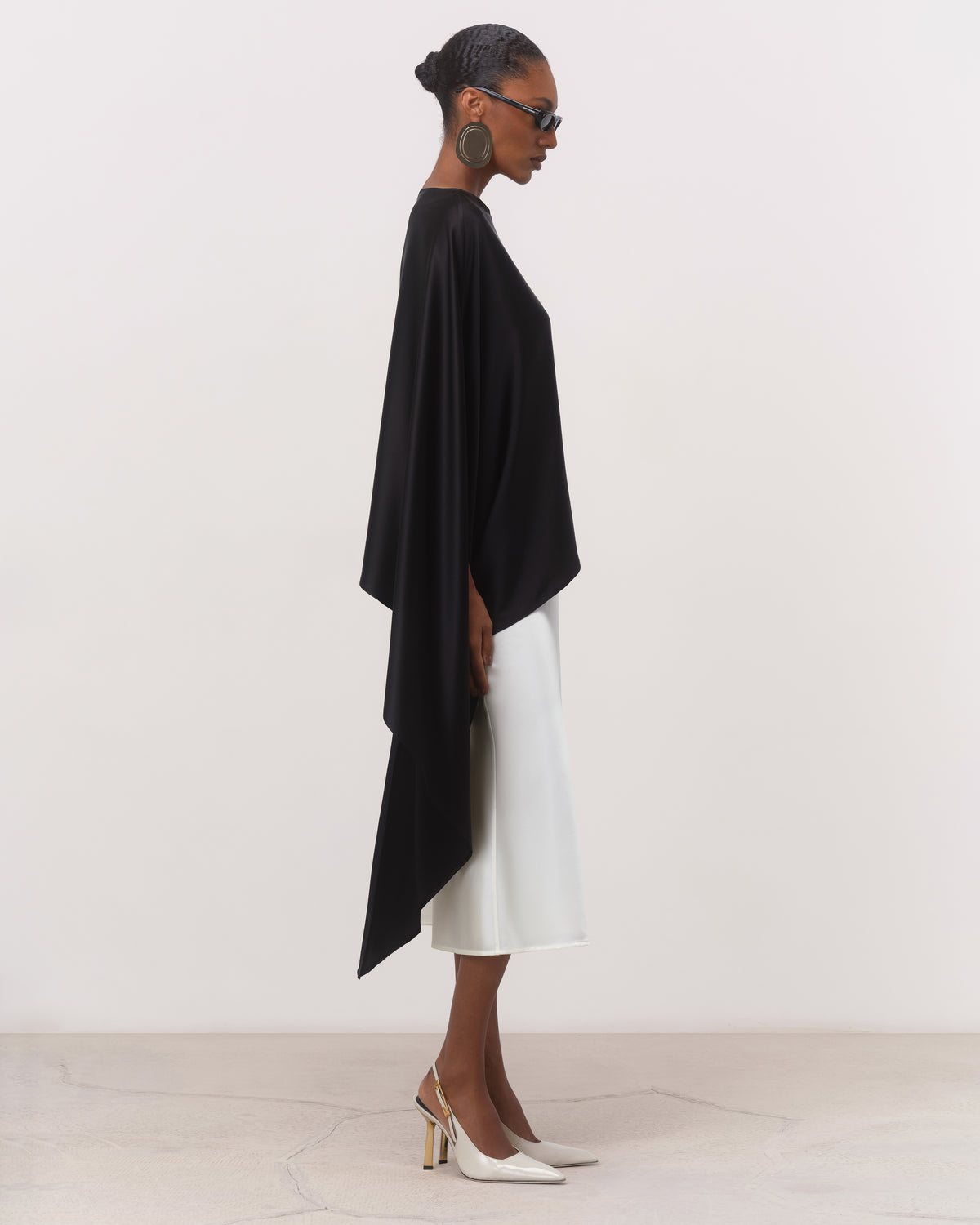 Side view of black silk cape top with flowing side drape