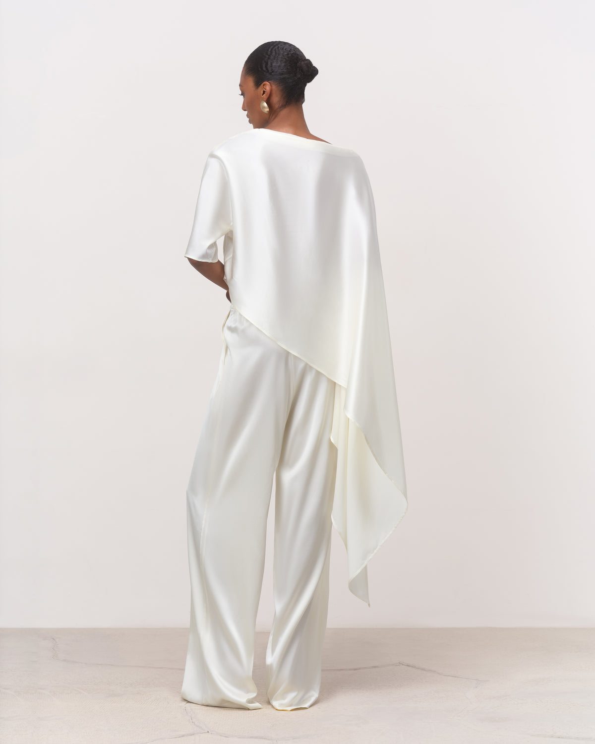 Back view of white mulberry silk boat neck top with cape drape